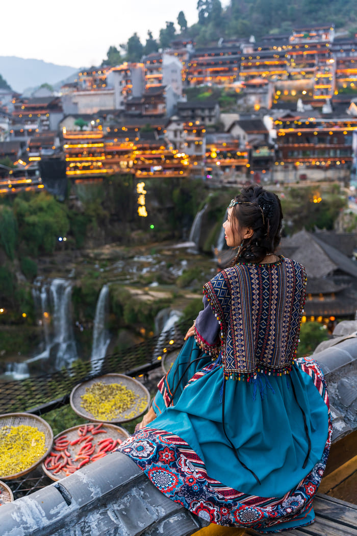 Mujer disfrutando la vista de la ciudad de lijiang